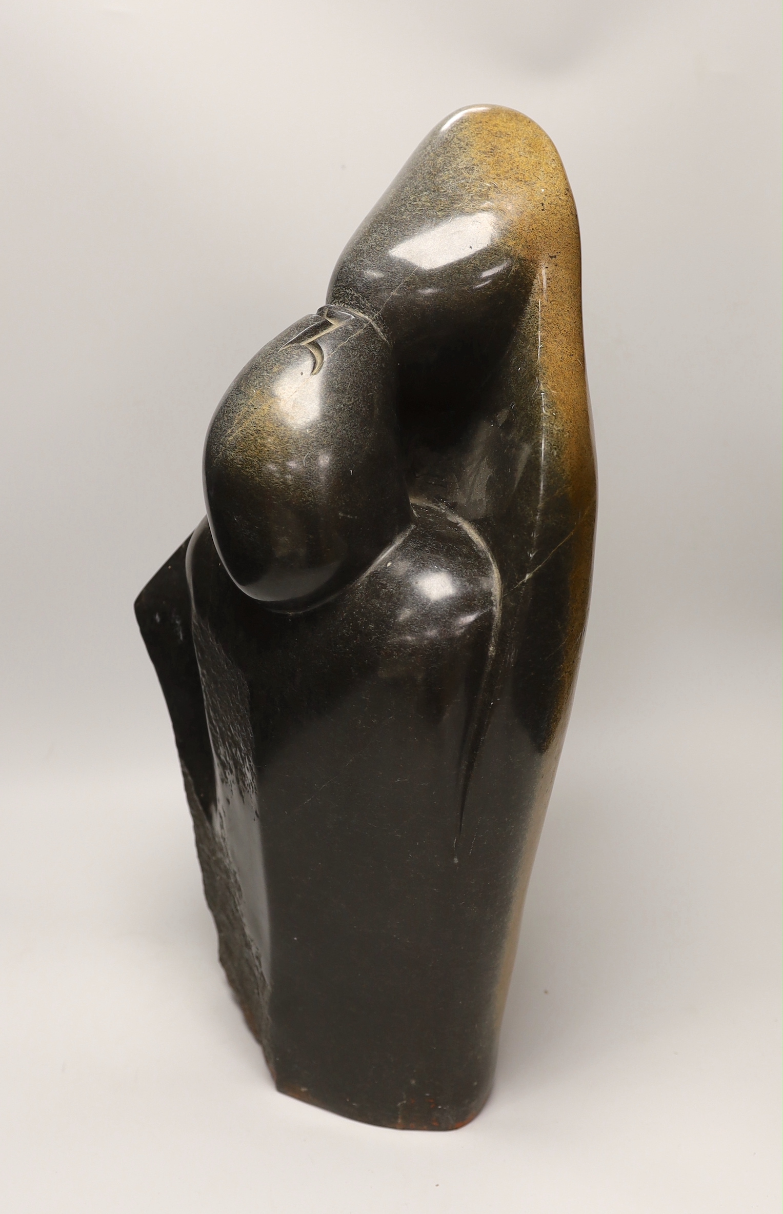 A Zimbabwe soapstone carving of two embracing figures, signed B Nehlimba, 53cm high